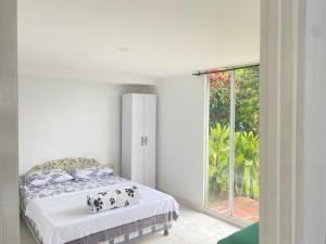 a bedroom with a bed and a large window at APARTAMENTO CAMPESTRE EN EJE CAFETERO in Manizales