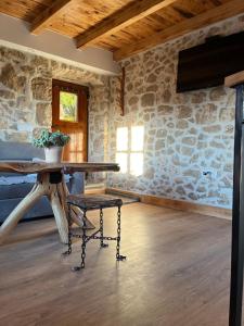 a room with a table and a chair in a stone wall at Stone House Chico in Ljubuški