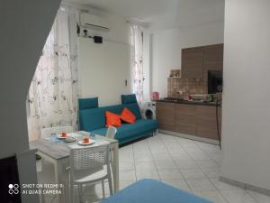 a living room with a blue couch and a table at Al Vicolo in Gaeta