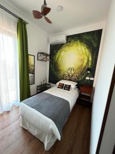 una camera da letto con un letto e un dipinto sul muro di Guest House Le Vagabonde a Fiumicino