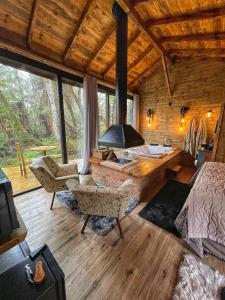 a bedroom with a bed and a fireplace in a log cabin at Cisne Negro Villarejo in Urubici