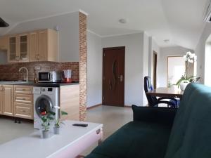 a living room with a couch and a kitchen at Muzicii 11 - Cozy Seaside Apartments in Năvodari