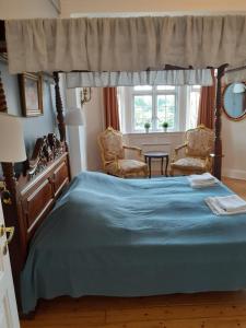 1 dormitorio con 1 cama grande y 2 sillas en Rent a Room Copenhagen en Copenhague