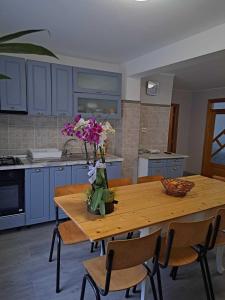 a kitchen with a wooden table with flowers on it at Muzicii 11 - Cozy Seaside Apartments in Năvodari