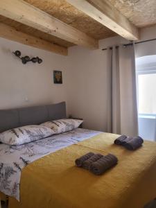 ein Schlafzimmer mit einem Bett mit zwei Paar Hausschuhen darauf in der Unterkunft Pjaceta in Cres
