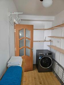 um pequeno quarto com uma máquina de lavar roupa e uma porta em Muzicii 11 - Cozy Seaside Apartments em Năvodari