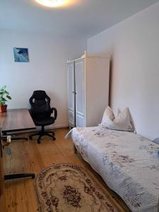 um quarto com uma cama, uma secretária e uma cadeira em Muzicii 11 - Cozy Seaside Apartments em Năvodari