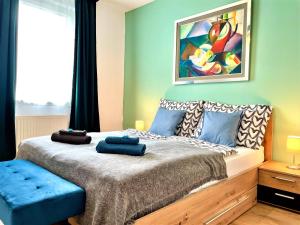 a bedroom with a bed with a painting on the wall at FEEL HOME DeLuxe CORVIN -FREE PARKING-AC-Elevator in Budapest
