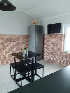 a kitchen with a black table and a refrigerator at Muzicii 11 - Cozy Seaside Apartments in Năvodari