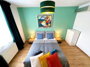 a bedroom with a large bed with colorful pillows at Feel Home DeLuxe CORVIN # FREE PARKING # AC # Elevator in Budapest