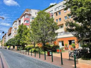 a street with a row of trees and buildings at Feel Home DeLuxe CORVIN # FREE PARKING # AC # Elevator in Budapest