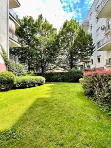 a green yard with bushes and trees in a building at Feel Home DeLuxe CORVIN # FREE PARKING # AC # Elevator in Budapest