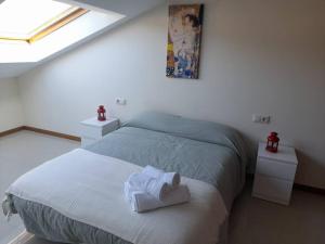Un dormitorio con una cama con toallas. en Atico Finisterre, en Finisterre