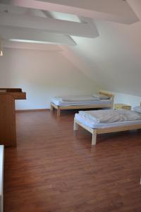 twee bedden in een kamer met een houten vloer bij Large house with parking, 30 min to Prague center in Úvaly