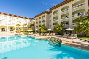 um hotel com piscina em frente a um edifício em Saui­pe Premium Sol All Inclusive na Costa do Sauípe