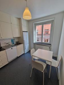 a kitchen with a table and chairs and a window at Home Inn KG49 in Stockholm