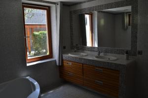 een badkamer met 2 wastafels, een spiegel en een raam bij Large house with parking, 30 min to Prague center in Úvaly