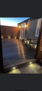 a deck with two benches and a building with lights at Lake District Coastal cottage in Seascale