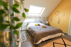 a bedroom with a bed in a attic with a window at La Reserve in Brugelette