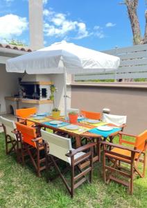stół z krzesłami i biały parasol w obiekcie Sweet Makri Suite w mieście Nea Makri