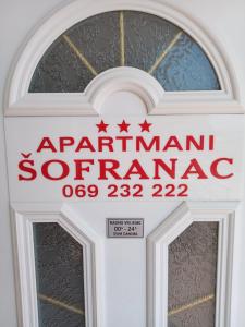 a sign on the door of an entrance to anarma synagogue at Apartments Šofranac in Podgorica