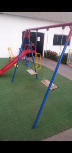 um parque infantil com dois baloiços num quintal em Apt próx. Shopping Pantanal/Centro Político em Cuiabá