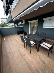 a patio with a table and chairs on a deck at Blue Star #4 in Paralia Katerinis