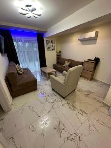 a living room with a couch and a chair at Blue Star #4 in Paralia Katerinis