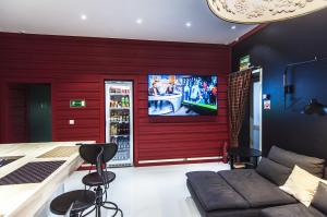 a living room with a red wall with a tv at KoikaGO Hostel in Kaliningrad
