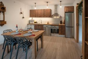 Apartament Rural La Colomina في Bernúy: مطبخ مع طاولة خشبية مع كراسي وثلاجة