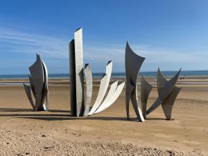 un grupo de esculturas de metal en la playa en Cottage OMAHA - 3 personnes - Plages du débarquement, en Formigny