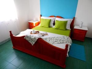 1 dormitorio con 1 cama grande con almohadas verdes en Apartments & Rooms Marinka, en Zadar