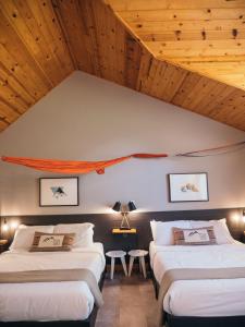 two beds in a room with wooden ceilings at LOGE Mt. Shasta in Mount Shasta