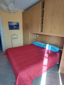 een slaapkamer met een groot rood bed met blauwe kussens bij Verdemare in Pietrabruna