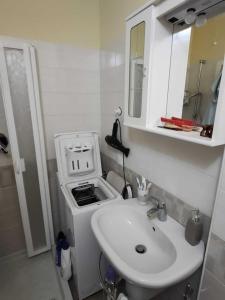een witte badkamer met een wastafel en een fornuis bij Verdemare in Pietrabruna