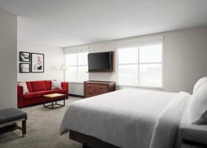 une chambre d'hôtel avec un lit et un canapé rouge dans l'établissement Holiday Inn - Cincinnati - Liberty Way, an IHG Hotel, à West Chester