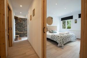 1 dormitorio con cama y pared de ladrillo en Apartament Rural La Colomina en Bernúy