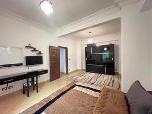 a living room with a tv and a couch and a desk at Apt in The Heart of Zamalek in Cairo