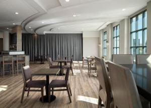 a dining room with tables and chairs and windows at Holiday Inn - Cincinnati - Liberty Way by IHG in West Chester