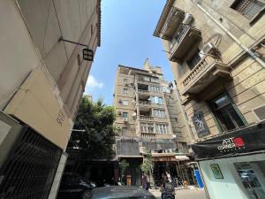 a city street with tall buildings and a building at Apt in The Heart of Zamalek in Cairo