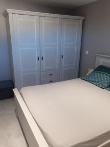 芒德的住宿－Proche centre ville，卧室配有一张白色大床和橱柜。