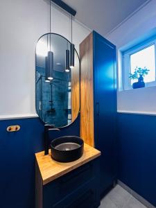 ein Bad mit einem schwarzen Waschbecken und einem Spiegel in der Unterkunft Bliżej Lasu in Śliwice
