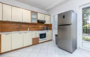 La cuisine est équipée de placards blancs et d'un réfrigérateur en acier inoxydable. dans l'établissement Stunning Apartment In Spincici With Wifi, à Jušići