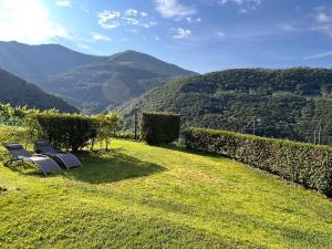 two chairs on a grassy hill with mountains in the background at Rustico Campei in Medeglia