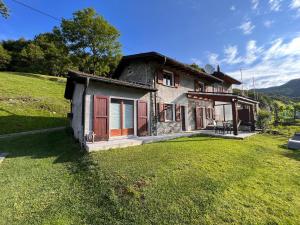 a small house on a hill with a yard at Rustico Campei in Medeglia