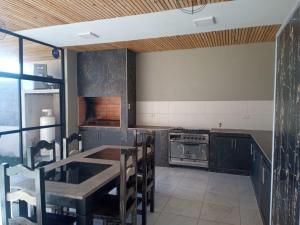 uma cozinha com uma mesa e um fogão forno superior em CASA TIPO CHALET SALTA em Salta