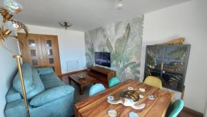 sala de estar con mesa y sofá azul en Apartamento Capricho Finisterre Playa, en Finisterre