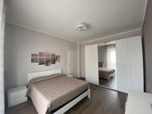 una camera bianca con letto e specchio di La casa di alice2 a Vercelli