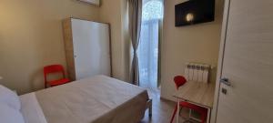 Schlafzimmer mit einem Bett, einem Schreibtisch und einem Fenster in der Unterkunft Happy b&b in Torre Maggiore