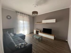un soggiorno con divano blu e TV di La casa di alice2 a Vercelli